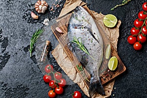 Fresh fish dorado. Raw dorado fish and ingredient for cooking. Fresh fish gilt-head bream dorade with salt, herbs and pepper.