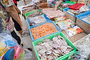 Fresh fish packed in clear bags laying on the table at the local food stall are being picked up by many customers