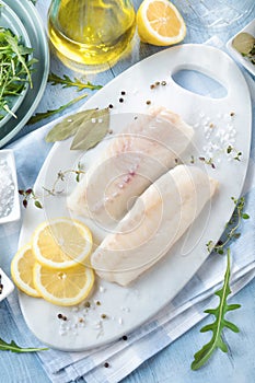 Fresh fish, raw cod fillets with addition of herbs and lemon.