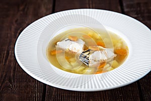 Fresh fish soup with pike perch and vegetables in a white plate