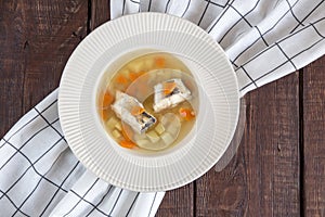 Fresh fish soup with pike perch and vegetables in a white plate