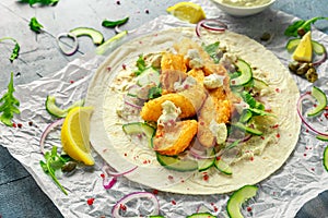 Fresh Fish Tortilla with cucumber, red onion, Capers, lemon, salad leaves and tartare sauce. Healthy Food