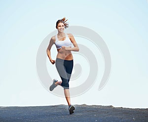 Fresh and fit female. Shot of a sporty young woman enjoying a run outdoors.