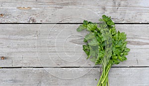 fresh, flat-leaf parsley on a light wooden background