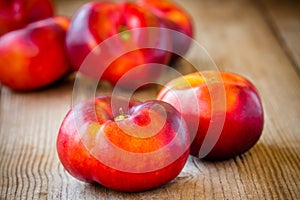 Fresh flat nectarines on a wooden background