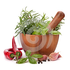 Fresh flavoring herbs and spices in wooden mortar