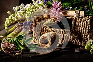 Fresh flowers, leaves, and tools to create a bouquet on a table, florist`s workplace