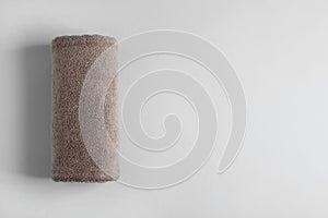Fresh fluffy rolled towel on grey background, top view