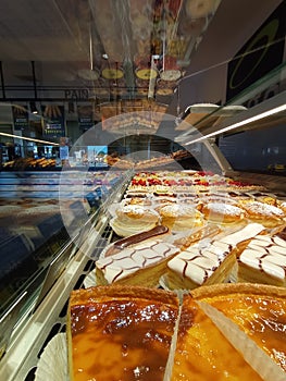 fresh food market, Bakery window with flans, millefeuille eclair and creamy tropezienne