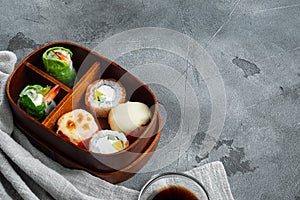 Fresh Food Portion in Japanese Bento Box with Sushi Rolls, on gray stone background , with copyspace  and space for text