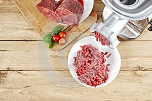 Fresh forcemeat, cutting board with Meat grinder on kitchen table. Top view
