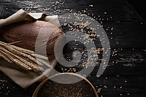 Fresh fragrant bread lies on a wooden table. Sieve with wheat