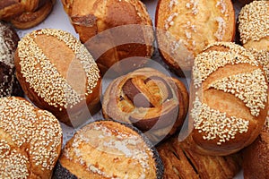 Fresh fragrant bread on the table, delicious buns with sesame and poppy seeds.