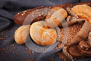 Fresh fragrant bread on the table. Food concept. Bakery, crusty loaves of bread and buns. Assortment of baked bread