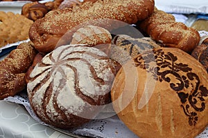 Fresh fragrant bread on the table, home-baked-loaf with sesame, loaf with sprinkles, bread with decoration.