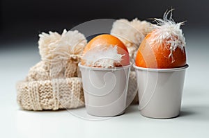 Fresh free range eggs with natural feathers in egg cups, eggs in woolen caps