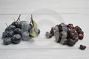 Fresh and freeze dried blueberry on the light wooden background