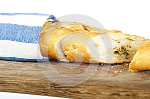 Fresh french bread on wooden board, wrapped in towel