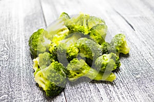 Fresh frozen broccoli on a wooden background, healthy diet, close-up