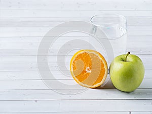 Fresh fruit Apple orange Cup of water on the table Diet