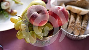 Fresh fruit - apples, peaches, grapes on the dinner table. Healthy eating as a way of life