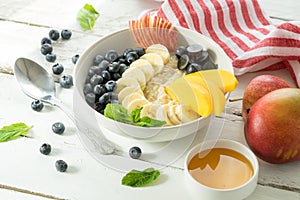Fresh fruit bowl hot porridge cereal wooden table