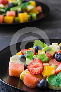 Fresh fruit salad on dark background. Close up