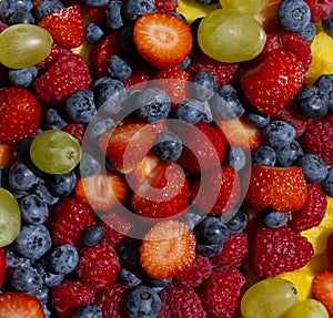 Fresh fruit salad. Grapes, blueberries, raspberries and strawberries. View from the top. Background of healthy fresh fruits