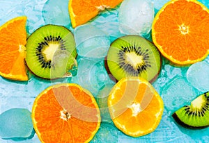 Fresh fruits background.Slices of fresh fruits top view on ice. orange and kiwi slices, fresh summer background banner