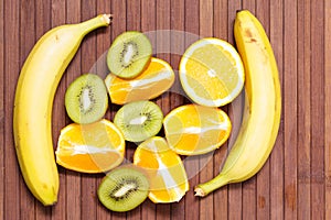 Fresh fruits banana, kiwi, orange isolated on wooden background. Healthy food. A mix of fresh fruit. Group of citrus fruits.