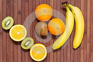 Fresh fruits banana, kiwi, orange isolated on wooden background. Healthy food. A mix of fresh fruit. Group of citrus fruits.