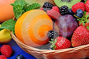 Fresh fruits in a basket on wooden table