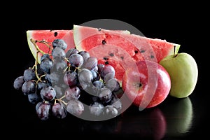 Fresh fruits on black background with reflection