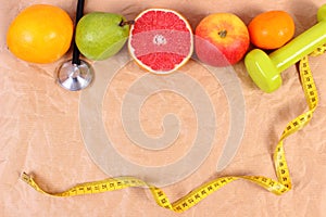 Fresh fruits, centimeter, stethoscope and dumbbells for fitness, concept of healthy lifestyles