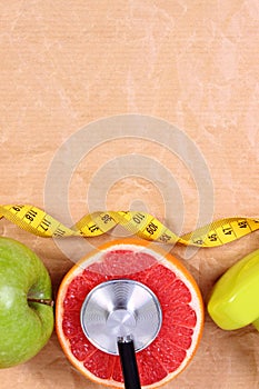 Fresh fruits, centimeter, stethoscope and dumbbells for fitness, healthy lifestyles