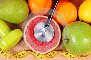 Fresh fruits, centimeter, stethoscope and dumbbells for fitness, healthy lifestyles