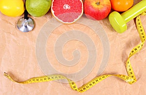 Fresh fruits, centimeter, stethoscope and dumbbells for fitness, healthy lifestyles