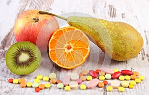 Fresh fruits and colorful medical pills, choice between healthy nutrition and medical supplements