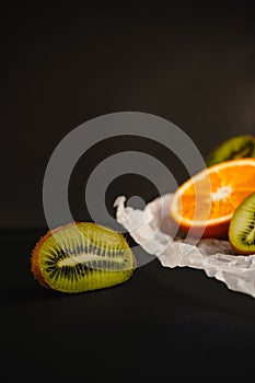 Fresh fruits on a dark background. Orange and kiwi in a cut isolated on a black background. Copy space. high resolution