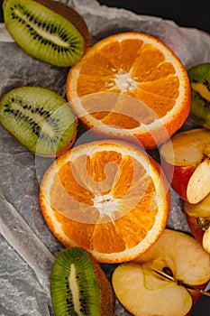 Fresh fruits on a dark background. Orange and kiwi in a cut isolated on a black background. Copy space. high resolution