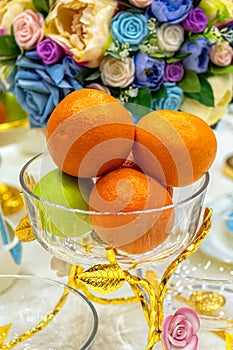 Fresh fruits in glass vase on festively decorated table