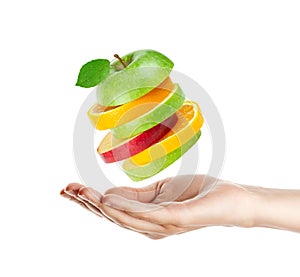 Fresh fruits. Hand and flying mixed fruits on white