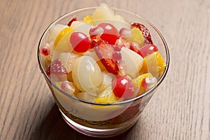 fresh fruits salad on glass bowl with wooden background