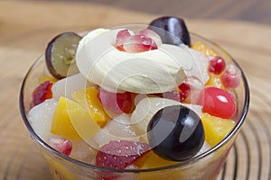 fresh fruits salad on glass bowl with wooden background