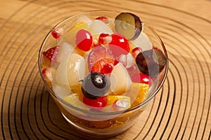 fresh fruits salad on glass bowl with wooden background