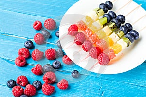 Fresh fruits on skewers in plate