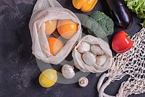 Fresh fruits and vegetables in eco cotton bags on table