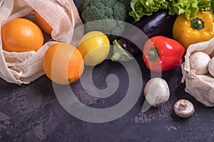 Fresh fruits and vegetables in eco cotton bags on table