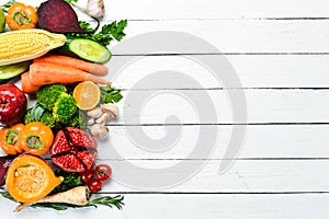 Fresh fruits and vegetables on white wooden background. Healthy food. Top view.