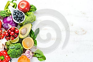 Fresh fruits and vegetables on a white wooden background. Top view.